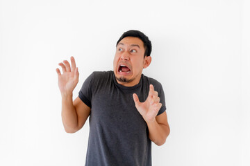 Funny man doing scary face and acting isolated on white background.