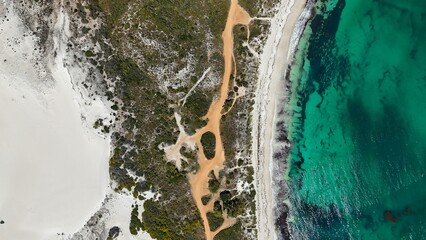 Aerial view of coastline with turquoise waters and sandy beach.