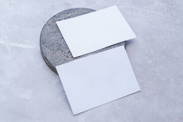 White blank business card mockup with stone decoration on grey background