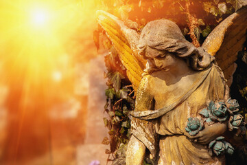 Beautiful sad angel as symbol of pain, fear and end of life. An ancient stone statue. Copy space for text or design.