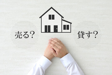 実家を売るか貸すかの処遇を考える人物の手元