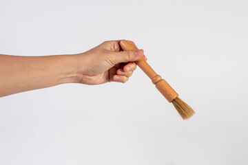 Hand using a wood little paintbrush isolated on a white background