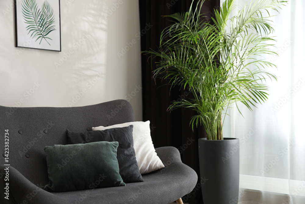 Poster comfortable sofa near window with elegant curtains in room