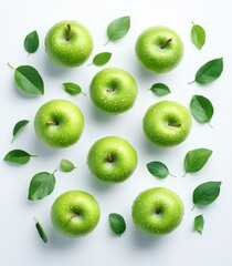 Fototapeta premium Delightful falling green apples with vibrant leaves captured from above on a crisp white backdrop for a fresh and healthy design