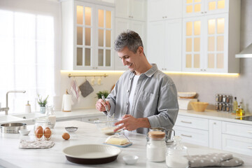 Man making dough at white marble table in kitchen