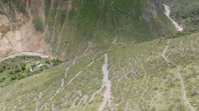 Drone shot capturing the descent along the winding path from Sangalle to Cabanaconde, with tourists riding mules, slowly making their way up through the Colca Canyon&rsquo;s breathtaking landscape.