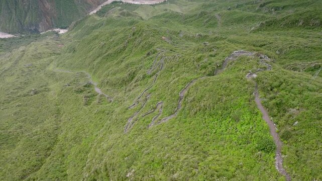 Drone shot following the trekking path from Cabanaconde to the Oasis of Sangalle, capturing hikers making their way down through the breathtaking Colca Canyon landscape.