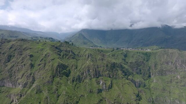 Drone shot from a greater distance, offering a sweeping view of the start of the trekking path from Cabanaconde, with the vast expanse of the Colca Canyon and the winding trail toward Sangalle.