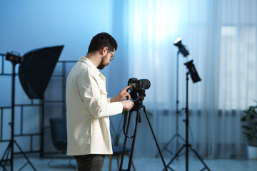 Man with professional video camera in studio