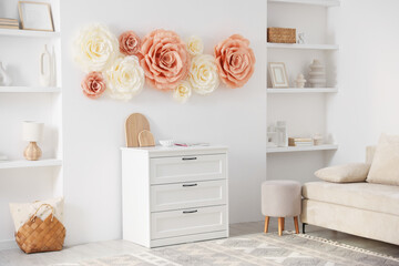Beautiful decorative paper flowers on wall in room