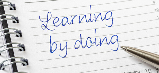 Obraz premium Learning by doing written on a calendar page