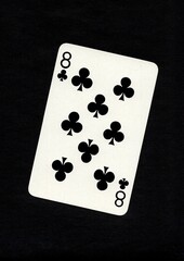 A playing card in the suit of clubs isolated on a black background.