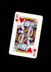 A playing card in the suit of hearts isolated on a black background.