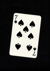 Playing card in the suit of spades isolated on a black background.