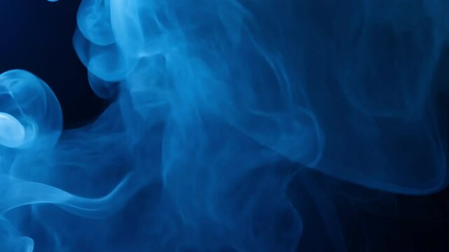 Mesmerizing blue smoke patterns create ethereal atmosphere, flowing gracefully against dark background, evoking sense of mystery and depth for creative projects.