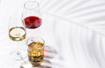A refined composition of wine glasses filled with red and white wine, paired with a whiskey glass