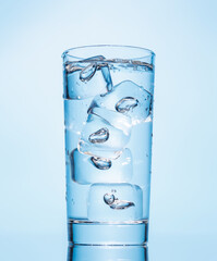 A clear glass filled with chilled water and ice cubes, creating a refreshing and cool drink