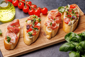 Tasty antipasto toasts featuring classic caprese with mozzarella and tomatoes, and savory prosciutto with herbs