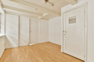 A spacious and uncluttered room featuring light wood flooring, white walls, and natural light streaming through windows, ideal for various uses.