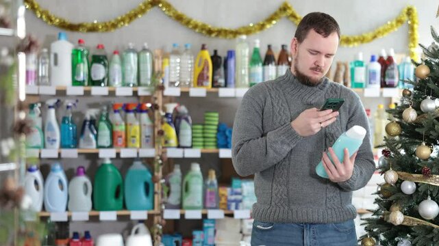 Checking expiration date of shower gel or champoo - male shopper scans QR code on label of shower gel or champoo using her smartphone. High quality 4k footage