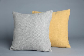 Two soft decorative pillows on grey background
