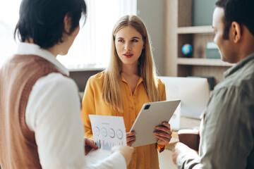 Business team discussing marketing strategy using tablet and documents