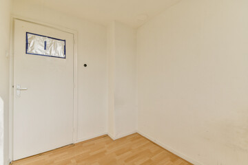A minimalistic view of an empty hallway featuring a white wall and a door, showcasing simplicity and a modern aesthetic in interior design.