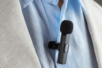 Man with lavalier microphone attached to his shirt, closeup