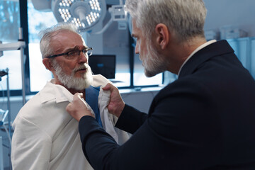 Aggressive man have conflict with doctor, holding him by coat.