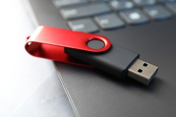 Flash drive and laptop on gray table, closeup