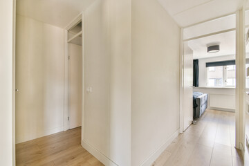 A clean and simple hallway featuring neutral colors and modern design elements. The space is well-lit and inviting, reflecting a minimalist aesthetic.