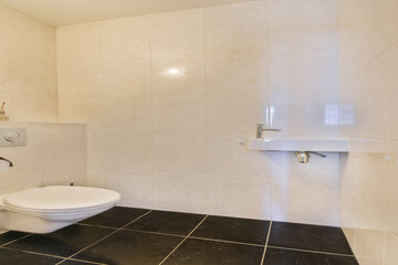 A clean and contemporary bathroom featuring sleek tiles, a minimalist design, and ample natural...