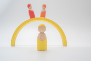 A yellow wooden man is in the front, another red wooden man and a tan wooden man are in the back on a bridge.