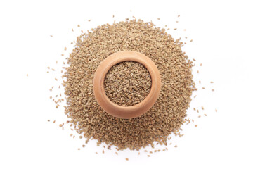 A mud pot filled with organic Carom seeds (Trachyspermum ammi) or Ajwain is placed on a heap of whole carom seeds, isolated on a white background.