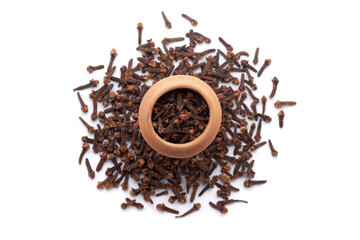 A mud pot filled with organic Clove (Syzygium aromaticum) or Indian long is placed on a heap of clove buds, isolated on a white background.