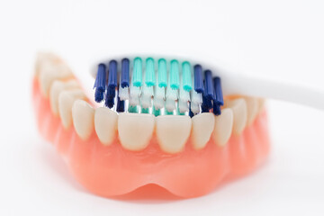 Obraz premium Cepillo de dientes limpiando una dentadura, aislado en blanco
