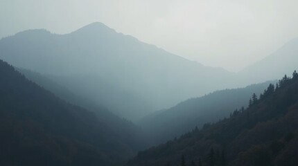 Fototapeta premium Misty mountain landscape with fog-covered forested peaks and valleys