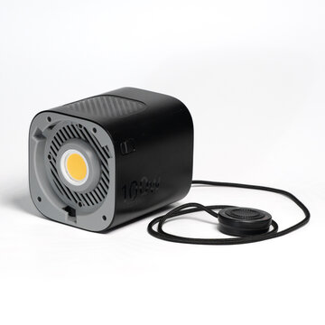Black Aputure 100d LED light with foot stand and remote controller on white surface