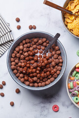 Breakfast chocolate balls in bowl on white background, top view.