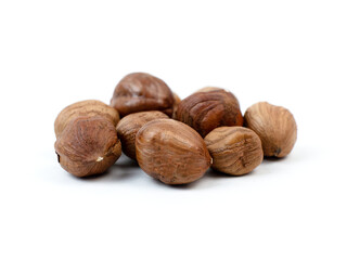 Hazelnuts gathered on a white surface