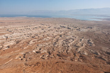 A desert landscape with a large body of water in the background