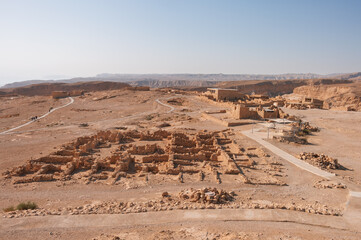 A desert landscape with a large building in the distance