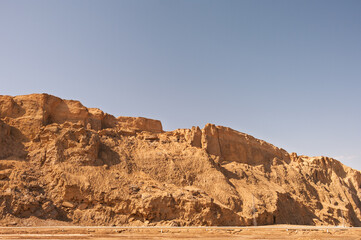 A rocky hillside with a clear blue sky in the background