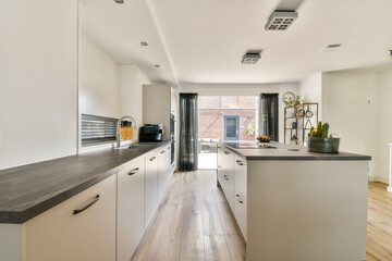 A stylish modern kitchen featuring sleek cabinets, wooden countertops, and abundant natural light, creating a warm and inviting atmosphere.