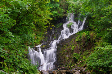 A waterfall is flowing down a rocky hillside