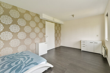 A minimalist bedroom showcasing light-colored walls with floral patterns, sleek furniture, and a cozy atmosphere. Perfect for serene living spaces.