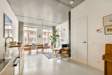 A sleek and modern living room featuring elegant furniture, large windows, and stylish decor, creating a bright and inviting atmosphere.