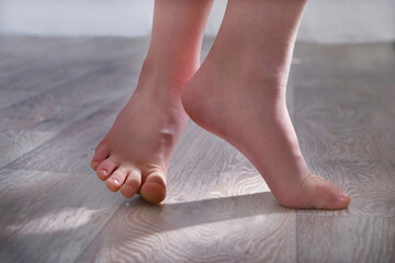 Barefoot teenage girl, dancer artist standing on tiptoe. Low section. Dance studio, tiptoe legs,...