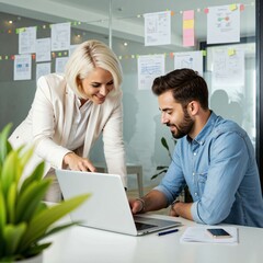 Obraz premium Blonde woman smiling while looking over the shoulder of a young man at a laptop screen in a bright office - a moment of teamwork, guidance, and learning in a collaborative business environment