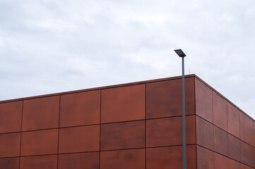 Modern building with corten steel facade and street lamp